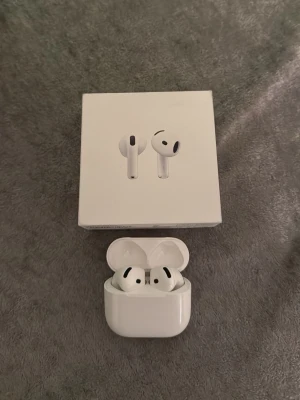 Apple AirPods 4 (2024) USB-C - Säljer ett par vita Apple AirPods 4 (2024) med trådlöst laddningsetui och USB-C. Hörlurarna har en stilren och modern design med rundade former och sitter bekvämt i öronen. Perfekta för musik, samtal och vardagsbruk.helt äkta köpte från Elgiganten användt bara i 2 veckor.