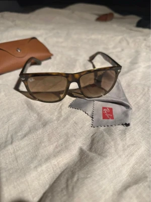 Ray-Ban solglasögon brunmelerade - Snygga solglasögon från Ray-Ban med brunmelerad båge och klassisk fyrkantig form. Tillbehör medföljs ej.