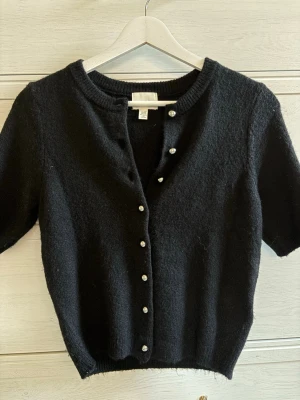 Supersnygg svart kofta - Säljer snygg svart kofta från hm. Storlek xxs. Den har små pärlor som knappar. Rensar garderoben. Nästan aldrig använd. PostNord prioriteras