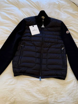 Svart Moncler cardigan S - Svart Moncler cardigan i storlek S, helt nytt skick för väldigt bra pris! Bild på lapparna o koden funkar (bild 4)! Pris kan diskuteras vid snabb affär!