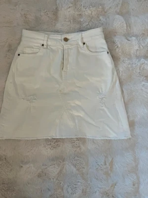 Vit jeanskjol från Guess - Säljer en vit jeanskjol från Guess med några snygga slitna detaljer framtill. . Perfekt till sommaren och enkel att styla💕Skriv om ni vill ha mått eller fler bilder 