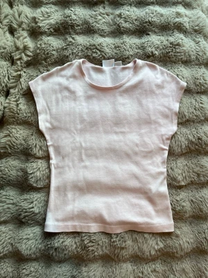 Ljusrosa topp från Gina Tricot - Säljer en enkel och stilren ljusrosa topp från Gina Tricot. Toppen har rund halsringning, ärmlös design och är gjord i mjuk bomull. Perfekt att matcha med jeans eller kjol för en fin look.💖