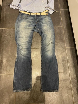 Blå jeans, bootcut - Snygga blå jeans med raka ben och slitna detaljer på framsidan. Jeansen har klassisk femficksdesign och ljusare tvättade partier för en trendig look. Perfekta för dig som gillar en avslappnad och stilren stil. Materialet är denim i bomull.