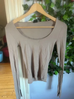 Beige långärmad topp från Gina Tricot - Långärmad beige tröja från Gina med slit i armarna, den har några små skador vilket jag kan skicka bild på vid intresse. 