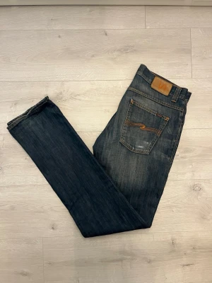 Nudie jeans med slitningar - Hej! Säljer dessa sjukt snygga nudie jeasen med slitningar//knappen vid gylfen är fixad//annars super sick//fråga gärna! 
