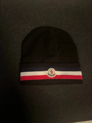 Moncler mössa - Helt ny aldrig använd. Säljer den eftersom jag inte passar i den.