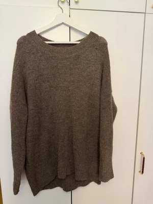 Brun stickad tröja från ONLY - Mysig brun stickad tröja från ONLY med rund halsringning och avslappnad passform. Tröjan har långa ärmar. Perfekt för lager på lager och enkel att matcha med jeans eller kjol.