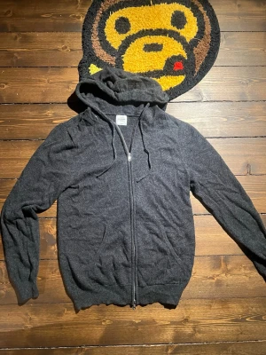 Mörkgrå cashmere hoodie John Henric - Mysig mörkgrå hoodie från John Henric i 100% cashmere. Tröjan har dragkedja framtill, justerbar huva.