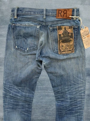 *NYA* RRL LOW STRAIGHT SELVEDGE JEANS - Ett par nya Double RL jeans i selvedge med en extremt fin wash, detta är definitivt det sjukaste paret jeans jag någonsin sålt! Som bilderna visar finns mindre stänk vilket är från fabrik och bidrar till looken på dessa. Nypriset ligger någonstans vid 5000-6000 kr. Storleken är 30/32 men utgå ifrån måtten! Mått: Midja - 40 cm, Ytterbenslängd - 104 cm, Benslut - 19 cm
