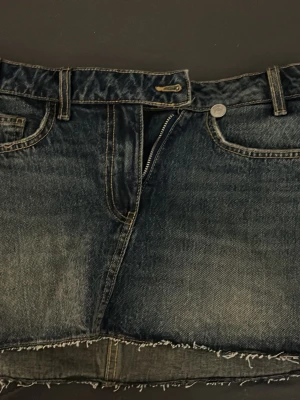 Jeanskjol - Säljer en jeanskjol från Zara i storlek xs, den är i bra skick och han bara används ett par gånger. Dock har jag klippt själv längst ner på kjolen, men klippningen är jämn.
