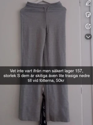 Grå mjukisbyxor med dragsko - Grå mjukisbyxor med raka ben och dragsko i midjan. Byxorna har en enkel och avslappnad design, perfekta för en chill stil. Materialet ser ut att vara mjukt och bekvämt, passar bra till vardagslooken.