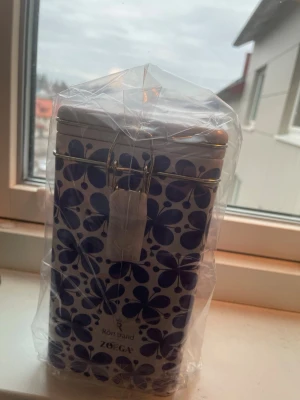 Viral kaffe plåtburk Rörstrand Zoégas - Viral plåtburk från Rörstrand i samarbete med Zoégas, dekorerad med det klassiska Mon Amie-mönstret i blått på vit botten. Designad av Marianne Westman. Perfekt för förvaring av kaffe eller te och har ett tättslutande lock i metall.