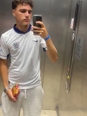 England fotbollströja Nike vit - Snygg vit England fotbollströja från Nike med blå detaljer och broderat landslagsmärke på bröstet. Tröjan har korta ärmar och sportig passform, perfekt för match eller träning. Materialet är lätt och andas bra. Vid mer info kontakta gärna! ABS! Pris går att diskutera! 