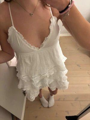 Vit volangklänning med spetsdetaljer, studentklänning, skolavslutning, vit klänning, mini klänning - Söt vit kortklänning med tunna axelband och djup v-ringning. Klänningen har flera lager volanger och spetsdetaljer. Perfekt till studenten eller skolavslutningen! 💕Klänningens ”storleks lapp” är bortklippta men är lite för kort för kort för mig som i vanliga fall har S och är 169cm lång! 