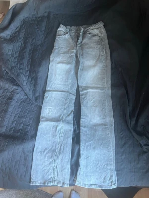 Ljusgrå bootcut jeans från Lindex  - Säljer ett par ljusgrå jeans med mid bootcut i passform. Perfekta för en avslappnad och trendig look. Använda ganska mycket för något år sedan💓i storlek 158/164