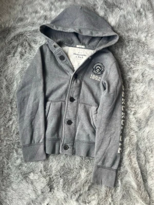 Grå hoodie från Abercrombie & Fitch - Säljer denna sällsynta och mycket eftertraktade Abercrombie & Fitch hoodie | Storlek S | Skick 9/10 | Vid eventuella frågor hör gärna av dig och erbjuder bra pris vid köp av bundle 😁✅
