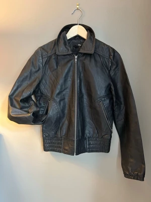 Bomerjacka 100 läder, pilotjacka - Skinnjacka 100 läder, fint skick på skinnet. Dragkedja samt innerficka. Nypris läderjacka på H&M 4000- 5000:- kr