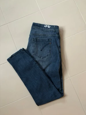 Dondup George jeans w36 blå - Blå stentvättade snygga populära trendiga Dondup George jeans i w36 säljes. 45 cm breda och 104 cm total längd. Inga hål eller fläckar i grymt skick verkligen! Sjukt snygga på, grym passform och jättefina perfekta nu till våren!
