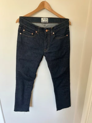 Acne Studios jeans - Säljer ett par raw denim jeans från Acne Studios som är avklippta, därav lite kortare. Passar ca 167
