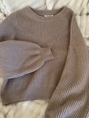 Stickad tröja  - Stickad tröja som är ribbad från NA-KD. Den är sparsamt använt men är lite nopprig, men eftersom redan kvaliten på tröjan så märker man inte. Den är super fin och skön på🤍