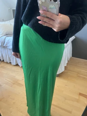 Grön långkjol  - Säljer en snygg grön långkjol från Mango. Kjolen är rak i modellen och är tillverkad i ett lite lätt glansigt material. Perfekt till sommaren!!😍😍 
