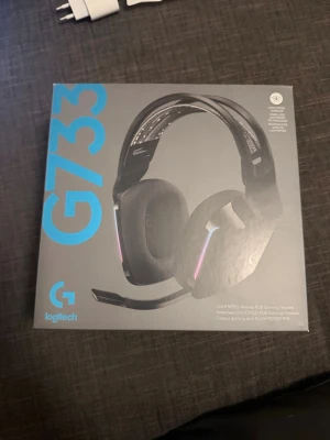Logitech G733 trådlöst gamingheadset - Säljer ett Logitech G733 trådlöst gamingheadset i svart med RGB-belysning. Hörlurarna har en avtagbar mikrofon, mjuka öronkuddar och justerbart huvudband. Medföljer USB-mottagare och laddkabel. Perfekt för gaming och streaming.