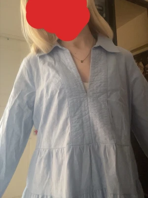 En vacker ljusblå klänning🩵🩵🩵 - En jätte fin ganska kort ljusblå klänning, den är v ringad och går lite neråt uppe vid halsen och den har långa fina ärmar. 