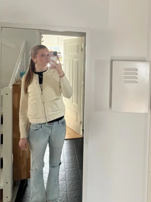 Beige quiltad cardigan jacka - Snygg beige quiltad cardigan med dragkedja framtill och två stora fickor. Den är i väldigt bra skick och knappt använd förutom en liten fläck som knappt synns och går säker bort. Den är i storlek L men liten i storleken så skulle säga xs-m