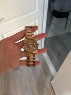 Guldig klocka från Michael Kors - Elegant klocka i roseguld från michael kors. Endast använt fåtal gånger. I fint skick.klassisk o passar till allt 