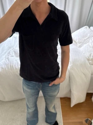 Marinblå  kortärmad polotopp i bomull - Säljer en marinblå polotopp i bomull med korta ärmar och klassisk krage. Toppen har en bröstficka och är i en normal passning, perfekt för dig som gillar en enkel och stilren look.