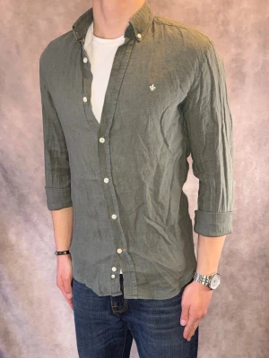 Olivgrön Morris Linneskjorta - Stl XS  - Riktig snygg Morris Linneskjorta Olivgrön, perfekt till sommaren som närmar sig! 🏖️🌊 | Mycket bra skick: 8,8/10, utan defekter!, behöver strykas | Stl: XS |  Modellen är 177cm och väger 75kg, sitter tight, rekommenderar att vara mellan 165-175cm | Hör av dig vid frågor // Galgen 🫡 