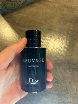 Dior Sauvage Eau de Parfum - Säljer en Dior Sauvage Eau de Parfum. Flaskan är mörkblå och cylindrisk med en elegant svart kork. Märket och parfymnamnet är tryckt i vitt på framsidan. Perfekt för dig som gillar fräscha och maskulina dofter. Fick en ny så säljer min gamla som har inga problem.