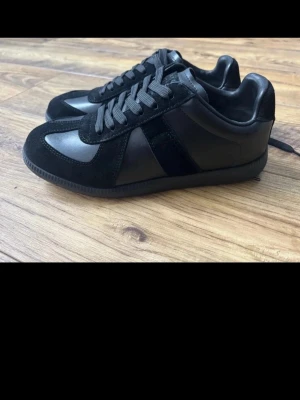 Svarta Maison Margiela - Snygga svarta sneakers från Maison Margiela. Storlek 38-39, bra skick! Hör av dig vid frågor eller nya bilder!! 