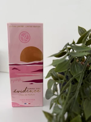 Évidence Limited Edition parfym Yves Rocher - Limited edition parfym från Yves Rocher, Évidence L'Eau de Parfum. Förpackningen är rosa med ett stiliserat solnedgångsmotiv i guld och lila toner. Flaskan rymmer 100 ml och är designad i elegant kartong.