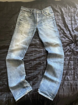 Ljusblå Slim jeans med slitningar från Emilio - Säljer ett par ljusblå jeans med slim ben och snygga slitningar på både fram- och baksida. Jeansen har klassisk femficksmodell och är tillverkade i denim med en tvättad look. Perfekta för en avslappnad och trendig stil.