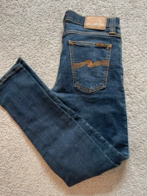 Nudie Jeans  - Säljer ett par klassiska blå jeans från Nudie Jeans. Jeansen är i riktigt bra skick. Storlek är 28/32. Priset är ej hugget i sten🤗