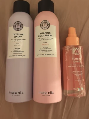 Maria Nila hårsprayer och doftmist - Tre produkter från Maria Nila: en lila Texture Spray, en rosa Shaping Heat Spray och en orange Floral Drift doftmist. Alla är veganska och kommer i snygga flaskor med svart och orange lock. Perfekt för styling och doft till håret.