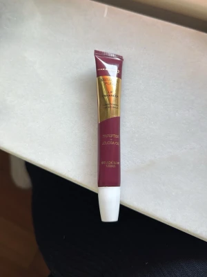 Max Factor Miracle Pure Lipgloss - Max Factor Miracle Pure Lip Enhancer i en mörkrosa nyans. Innehåller tripeptider och jojobaolja, vegansk formula. Perfekt för att ge läpparna glans och vård. Färgerna heter 060 Acai haze. Testad på handen 