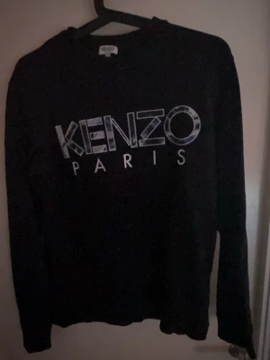 Kenzo Paris tröja – XS  - Säljer en stilren Kenzo tröja i svart med logga framtill. Använd men i mycket bra skick 👌  ✔️ Storlek: XS ✔️ Skick: 8/10 ✔️ Inga hål, fläckar eller skador ✔️ Säljs då den blivit för liten  Perfekt basic designerplagg som passar till allt.  💰 Pris: 499 kr (kan diskuteras vid snabb affär)