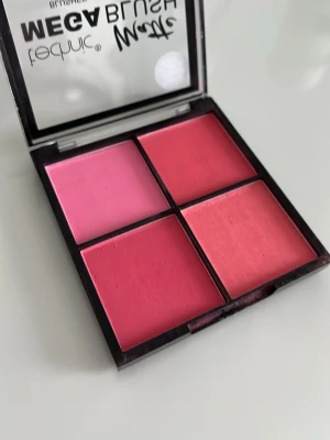 Technic Mega Blush Matte Rougepalett - Fyra matta rouge i olika rosa och koralltoner från Technic. Paletten innehåller både ljusrosa, mörkrosa och persikofärgade nyanser, perfekta för att skapa en fräsch look. Fyrkantig plastförpackning med genomskinligt lock.