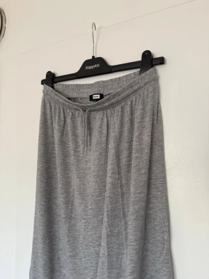 Långkjol - En enkel och skön grå långkjol från Bik Bok med elastisk midja. Kjolen är rak i modellen och gjord i ett mjukt material som passar perfekt för en avslappnad look. Perfekt att matcha med sneakers eller sandaler. Använd endast en gång🩶