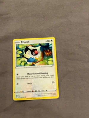 Pokémonkort Chatot - Säljer ett Pokémonkort med Chatot-motivet. Kortet har gul ram och färgglad illustration av Chatot i en grönskande miljö. Text och symboler i svart och grått, materialet är klassiskt glansigt papp. Perfekt för samlare eller Pokémonfans!