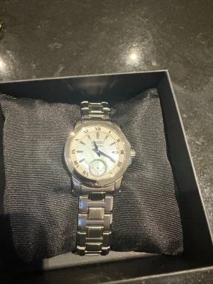 Seiko silverfärgad klocka i stål - Stilren Seiko klocka i silverfärgat stål med klassisk länkarmband och romerska siffror på urtavlan. Nypris 4300.