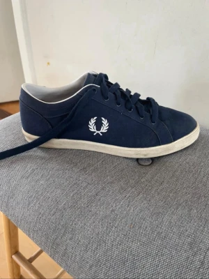 Mörkblå sneakers från Fred Perry - Snygga mörkblå sneakers från Fred Perry med klassisk låg profil och vit logga på sidan. Hör gärna av er om ni är intresserade!
