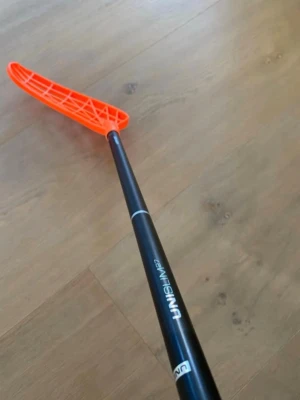 Unihoc unislim innebandyklubba  - Säljer en Unihoc innebandyklubba med svart skaft och orange blad. Klubban är enUNISLIM. 96cm och unilite blad med en spricka. Inga slagmärken eller liknande 