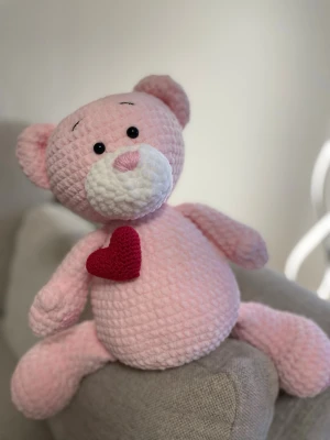 Stor virkad nalle med hjärta💕🎁💝 - Supergullig handvirkad nalle i mjukt rosa garn. Nallen har ett rött virkat hjärta på bröstet och är perfekt som present speciellt nu till morsdag eller till sig själv. Materialet är mjukt och fluffigt, vilket gör den extra kramvän.