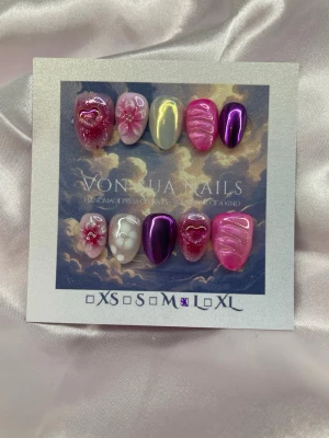 Bratzy (L);ExtraShortAlmond - Handgjorda press-on naglar i rosa, lila och vitt med metallic-effekt, 3D-blommor, hjärtan och swirl-detaljer. Mix av glansiga och kromade ytor, vissa naglar har pärldekor. Perfekt för dig som vill sticka ut med unika naglar.L: 17 mm, 12,5 mm, 13 mm, 12 mm, 10 mm 