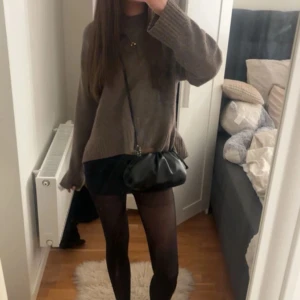 Brun stickad tröja från H&M XS - Mysig brun stickad tröja från H&M i storlek XS. Tröjan har en loose passform, rund halsringning och långa ärmar. Perfekt att slänga på sig över ett par jeans eller kjol för en chill look. Ribbstickade muddar vid ärmslut och nederkant. 