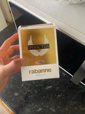 Paco Rabanne Invictus Elixir Parfym - Säljer en Paco Rabanne Invictus Elixir parfym. Flaskan har en unik troféform i guld och svart med metalliska detaljer. Förpackningen är vit och guld med vingmotiv och tydlig logga. En lyxig och modern doft för dig som vill sticka ut.
