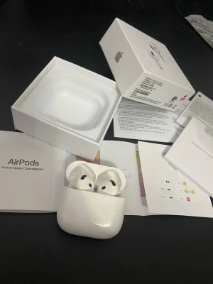 Apple AirPods Pro med laddningsetui - Säljer ett par vita Apple AirPods Pro med aktiv brusreducering och trådlöst laddningsetui. Snygg och kompakt design i blank plast, perfekt för musik, samtal och gaming. Originalförpackning och manualer medföljer.